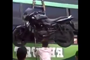 Inder hebt Motorrad mit dem Kopf